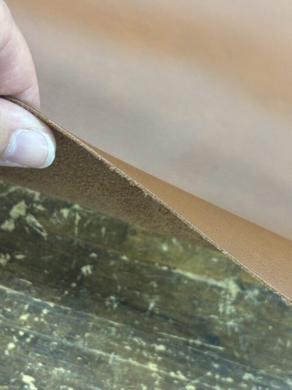 Brown leather being held up by a hand.