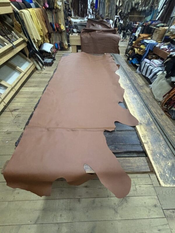 Brown leather hide on wooden table.