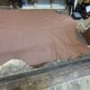 Brown leather hide on wooden table.