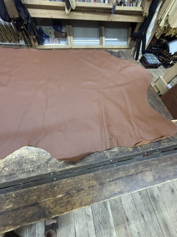 Brown leather hide on wooden table.