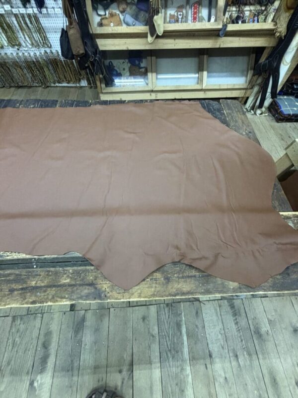 Brown leather hide on wooden table.