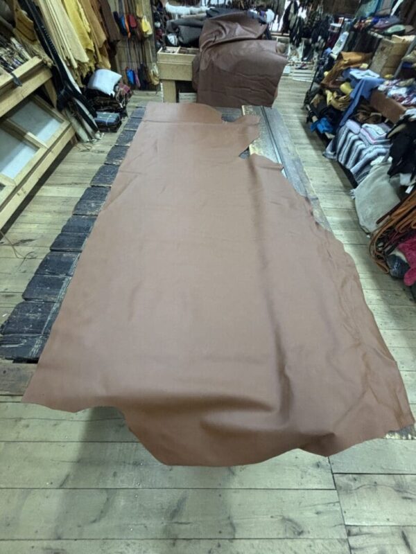 Large brown leather hide on wooden floor.