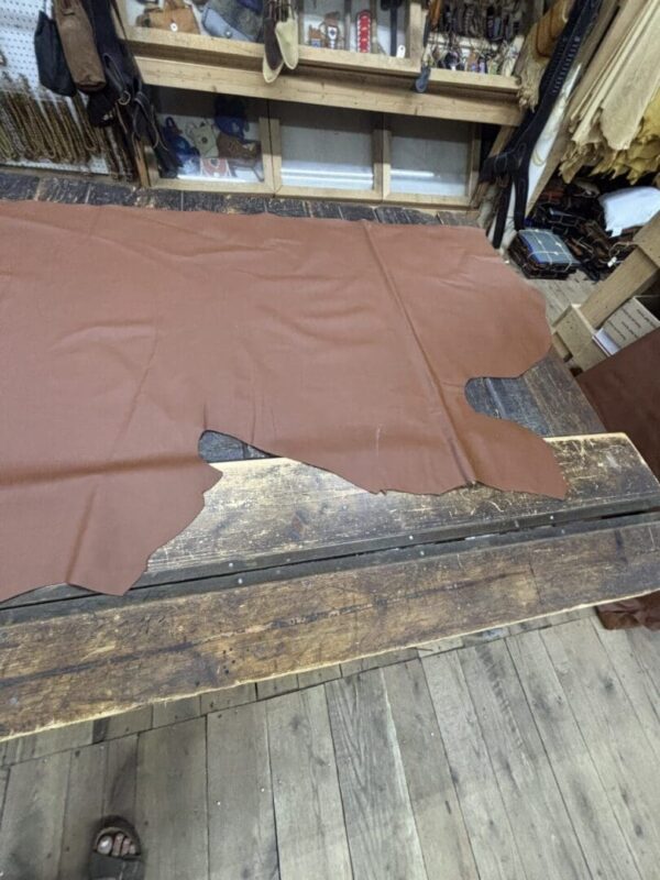 Brown leather hide on wooden table.