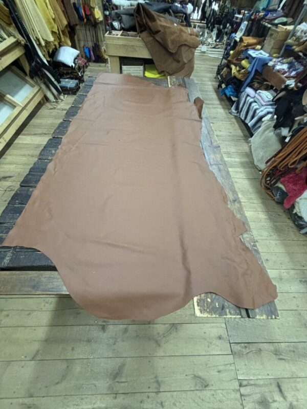 Brown leather hide on wooden table.