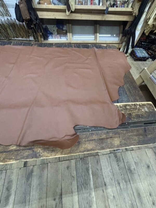 Brown leather hide on wooden surface.