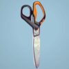 Black and orange scissors on blue background.