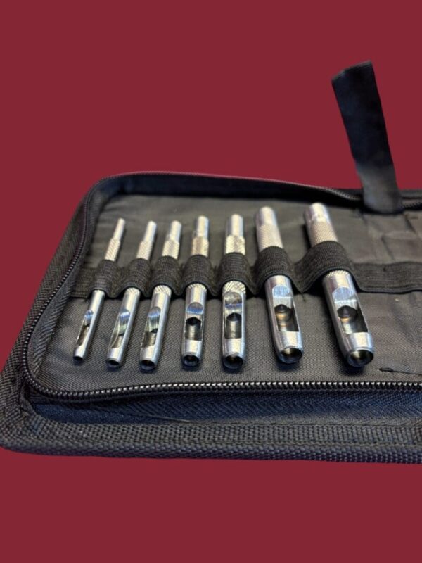Set of metal hole punch tools in a case.