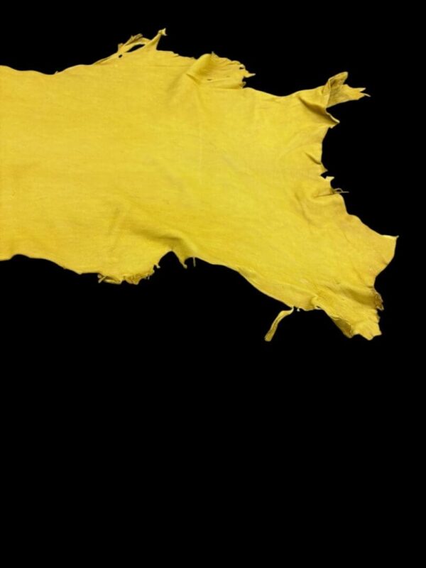 Yellow fabric with frayed edges on black background.