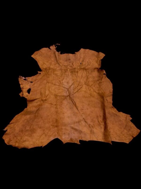 Ancient leather garment on black background.