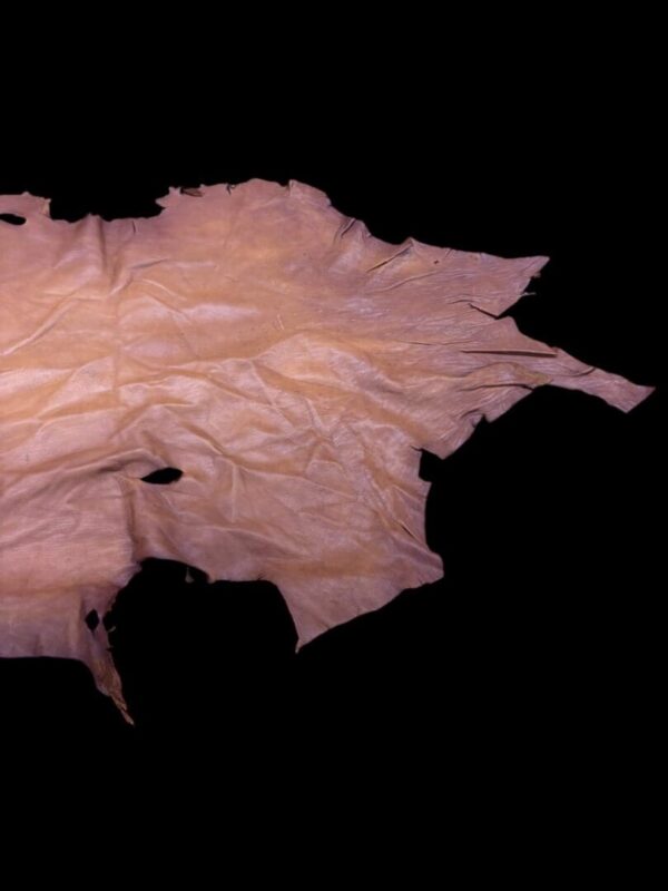 Brown leather piece on black background.