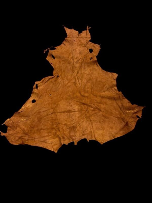 Brown leather piece on black background.