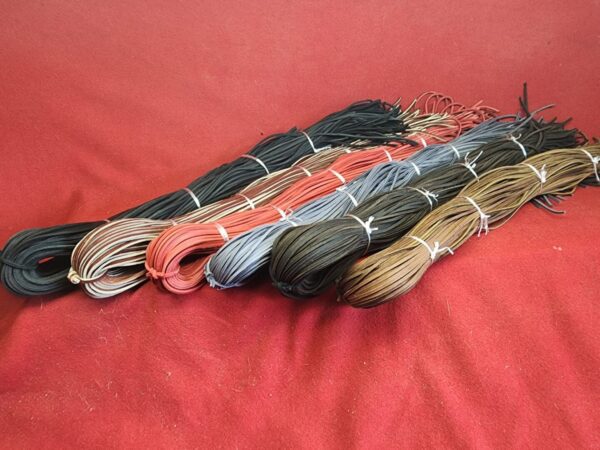 Assorted colorful cords arranged on fabric.