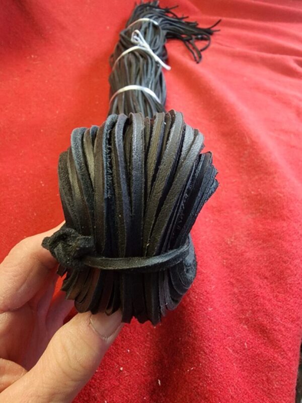 Black leather strips bundled in hand.