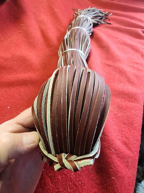 Braided leather strips on a red surface.