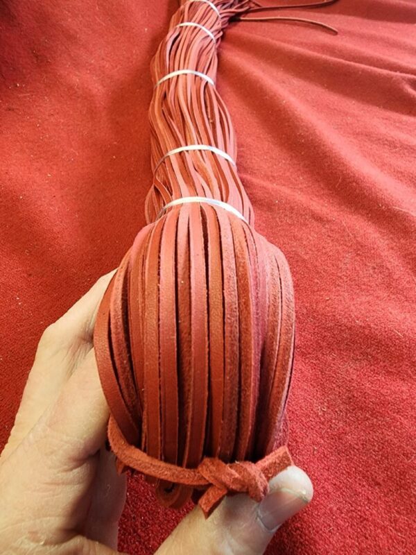 Red leather strips bundled in hand.