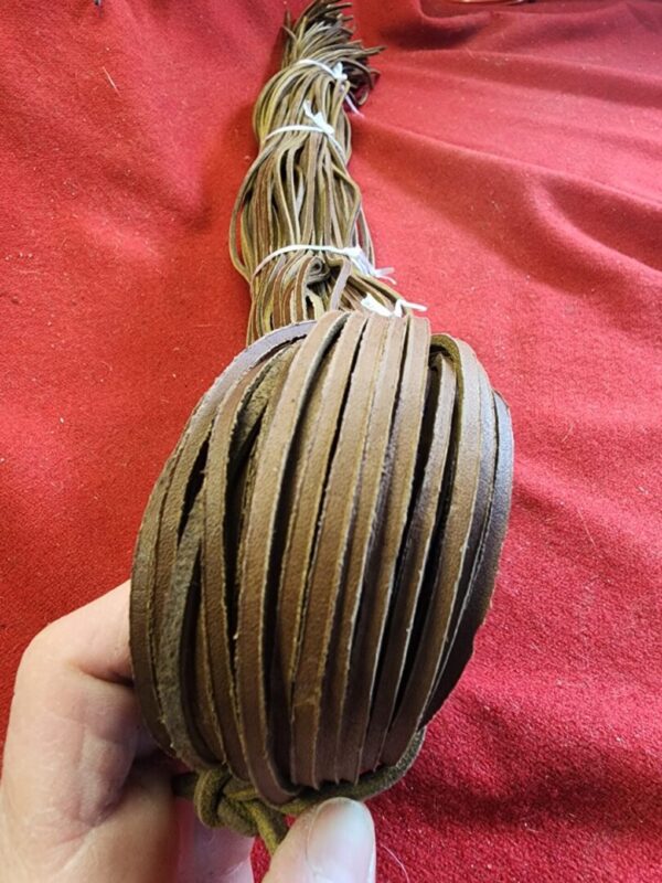 Rolled leather strips held in hand.