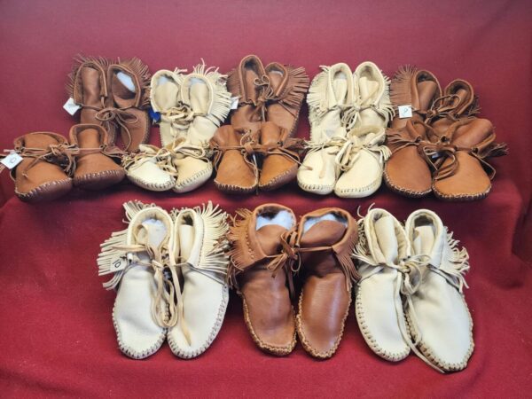 Assorted leather moccasins displayed on fabric.