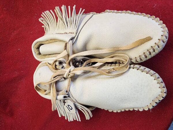 Traditional handmade leather moccasins with fringe.
