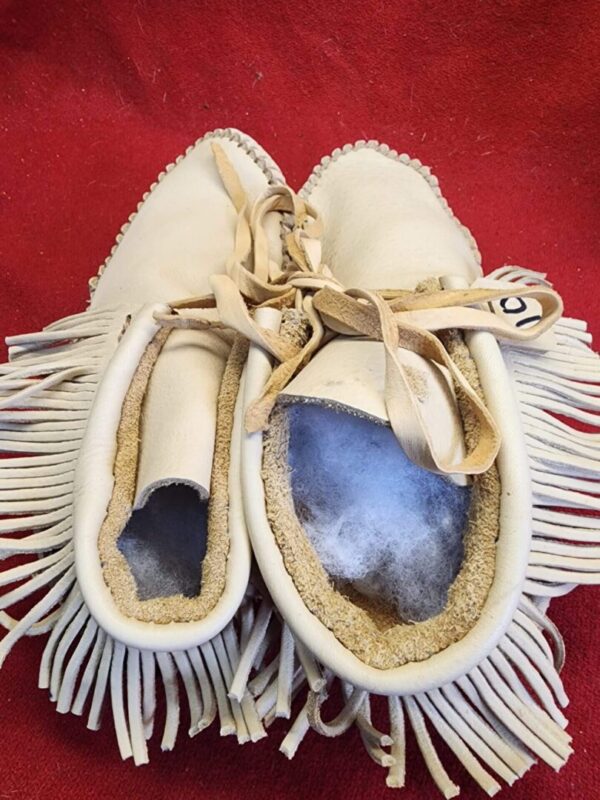 Traditional leather moccasins with fringe detail.