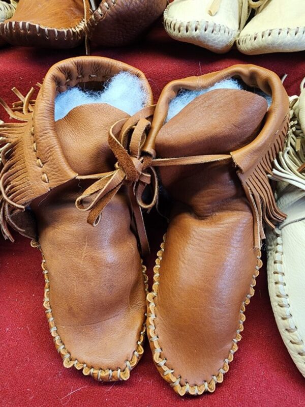 Leather moccasins with decorative stitching.