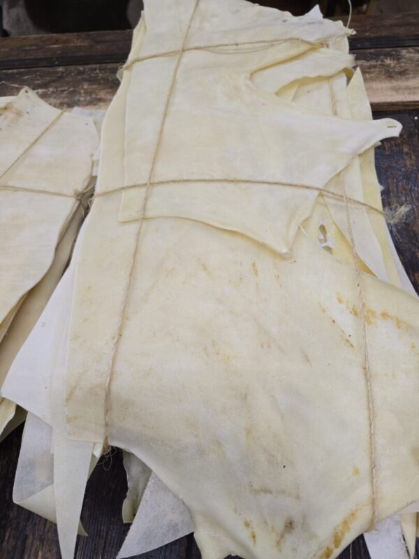 Dried animal hides bundled with string.