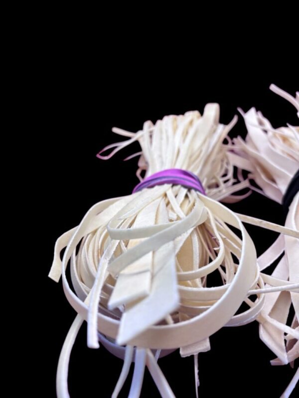 Bundle of white rubber bands on black background.