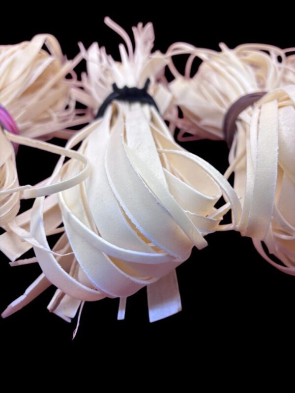 Bundles of spiral-cut pale rubber bands.