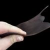 Hand holding a flexible piece of leather.