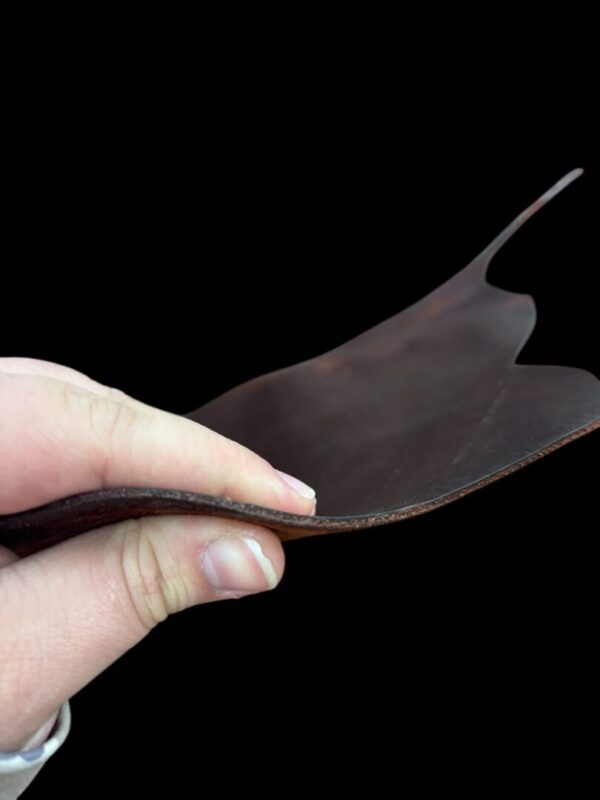 Hand holding a flexible piece of leather.