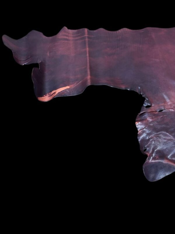 Textured, dark leather piece on black background.