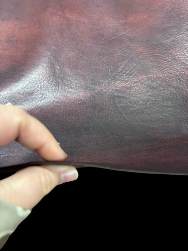 Hand holding a piece of leather.