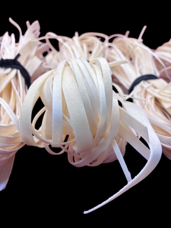 Bundles of thin, pale ribbons on black background.