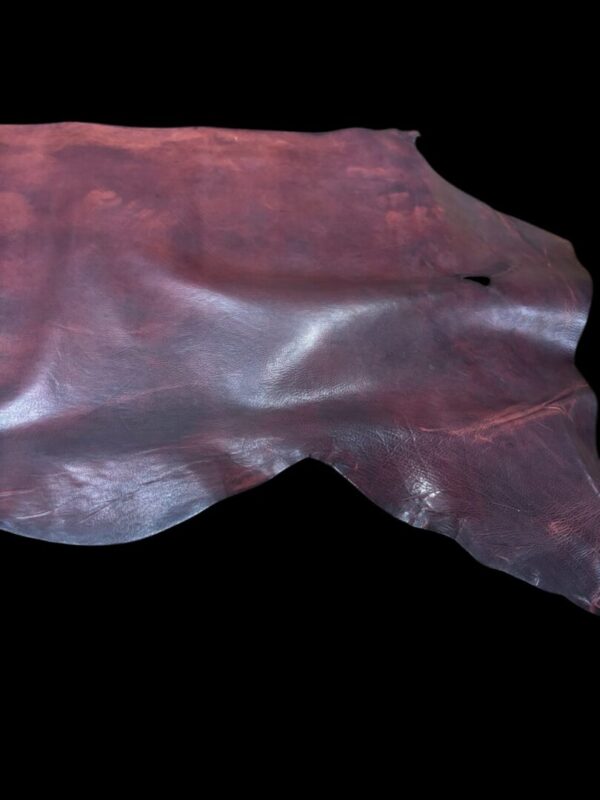 Brown leather piece on a black background.