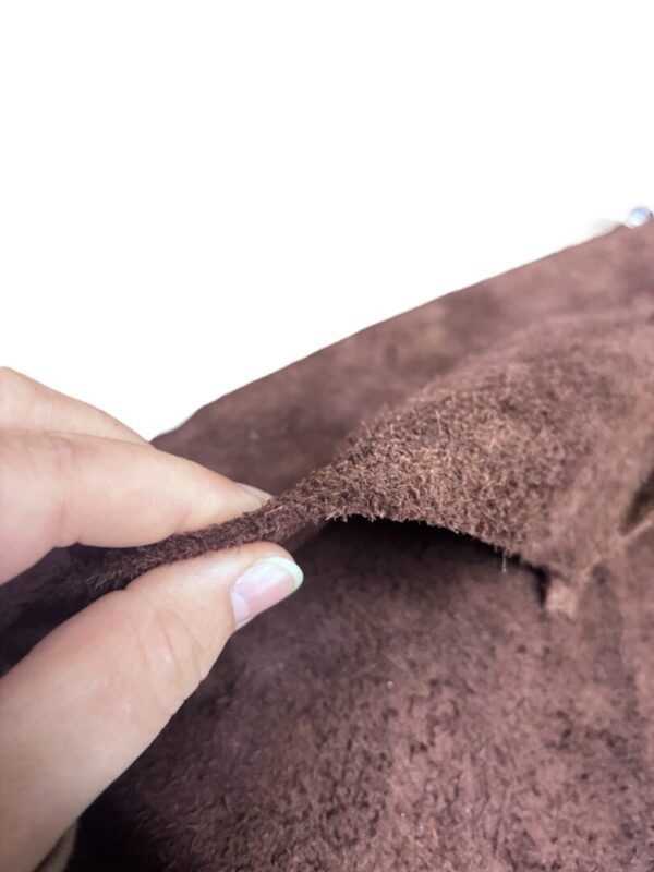 Hand holding a piece of brown leather.