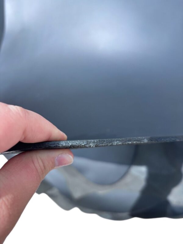 FCTZ3551 Hand holding thin black sheet close-up.