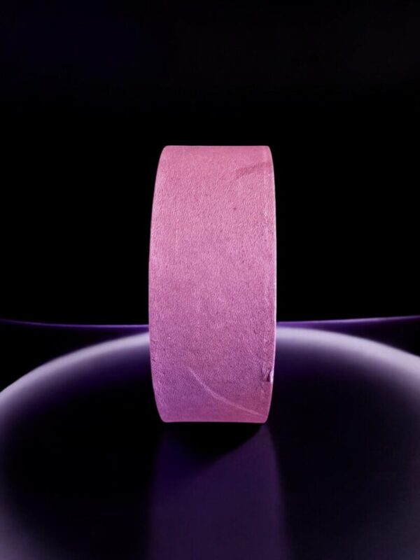 Pink roll of tape on black background.