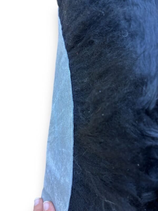 Close-up of a blue and black textured fabric with a white background.